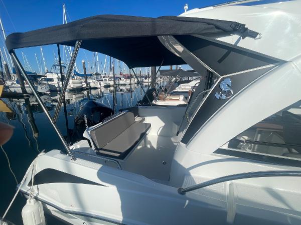 Slide: The Image of 2022 Beneteau Antares 7 boat docked at marina with canopy and seating area. - 4