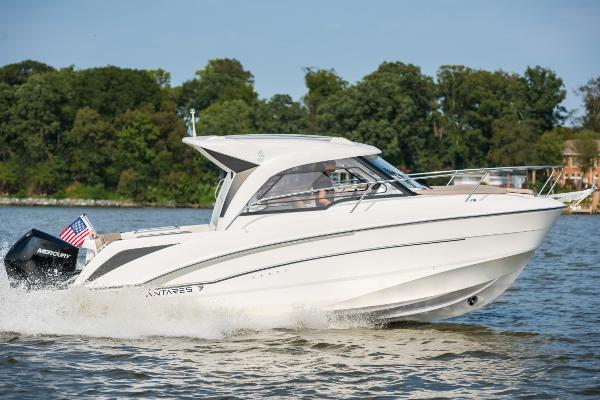 Slide: The Image of 2025 Beneteau Antares 7 motorboat cruising on a lake with trees in the background. - 1