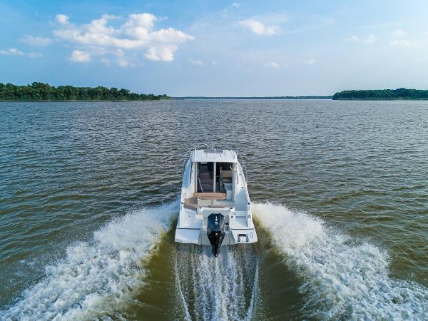 Slide: The Image of 2025 Beneteau Antares 7 cruising on a serene lake under a clear blue sky. - 3