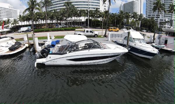 Slide: The Image of 2020 Beneteau Flyer 32 docked at marina with palm trees and buildings in background. - 1