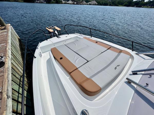 Slide: The Image of 2024 Beneteau Flyer 9 SUNdeck boat with spacious sunbathing area docked by the water. - 19