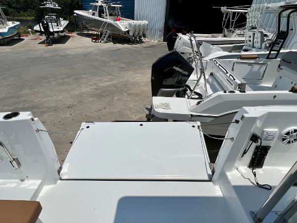 Slide: The Image of 2024 Beneteau Flyer 9 SUNdeck boat at a marina, showcasing the rear deck and outboard motor. - 7
