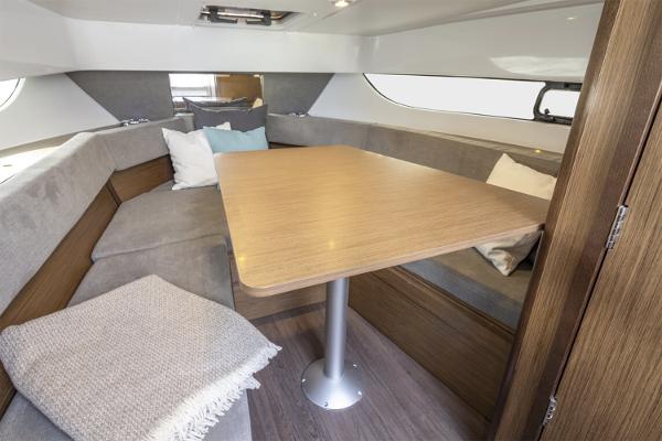 Slide: The Image of 2024 Beneteau Flyer 9 SUNdeck interior with cozy seating and wooden table. - 7