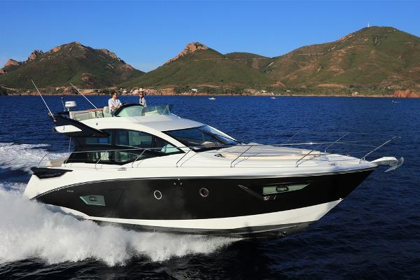 Slide: The Image of 2021 Beneteau Gran Turismo 50 Sportfly cruising on open water with scenic mountain backdrop. - 3