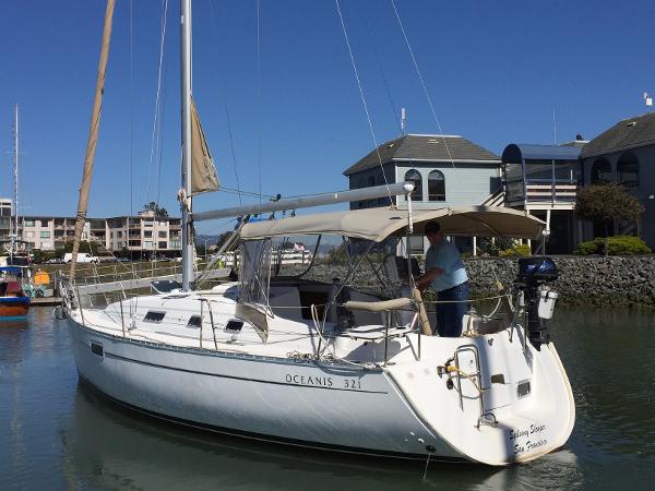 Slide: The Image of 2000 Beneteau Oceanis 321 sailboat docked in a marina under clear blue skies. - 0