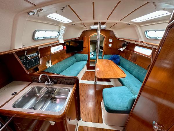 Slide: The Image of Interior of 2000 Beneteau Oceanis 321 sailboat with wood finish and teal seating. - 10