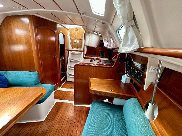 Slide: The Image of Interior of 2000 Beneteau Oceanis 321 sailboat with wood finish and teal seating. - 14