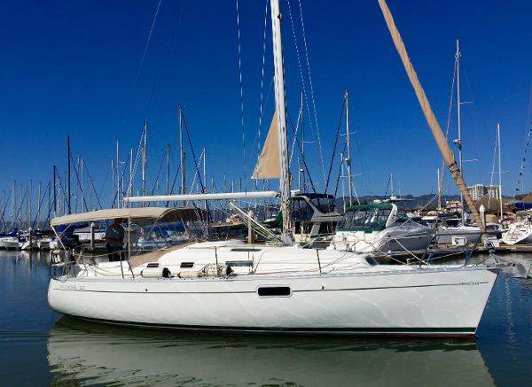 Slide: The Image of 2000 Beneteau Oceanis 321 sailboat docked in a marina under clear blue skies. - 2