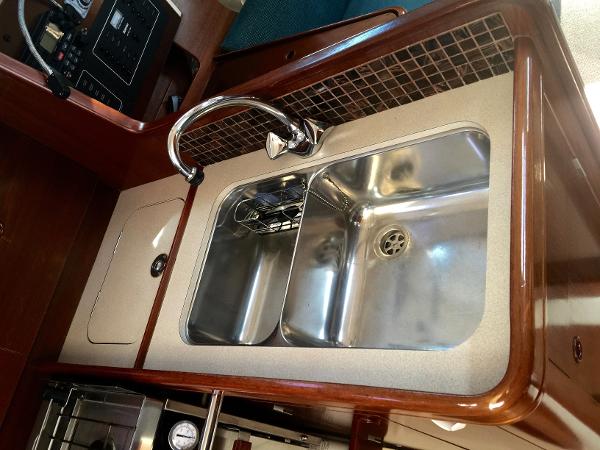 Slide: The Image of Galley sink in 2000 Beneteau Oceanis 321 yacht, featuring stainless steel and wood finish. - 24