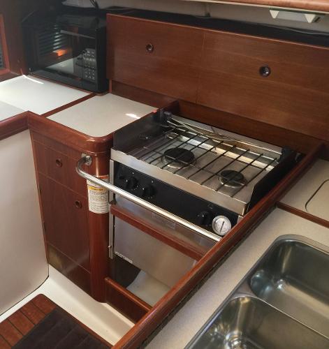 Slide: The Image of 2000 Beneteau Oceanis 321 yacht kitchen with stove, microwave, and sink. - 25