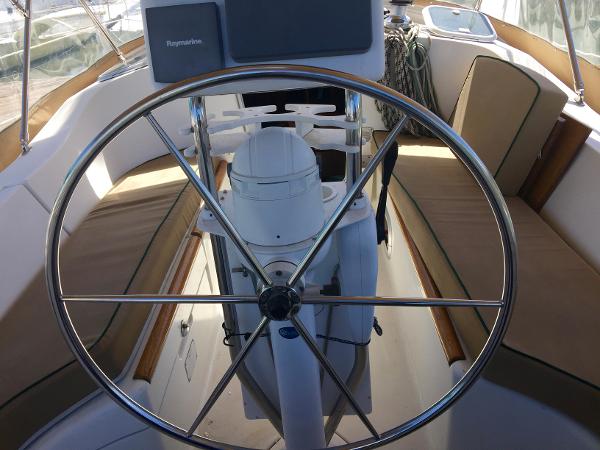 Slide: The Image of Steering wheel of a 2000 Beneteau Oceanis 321 sailboat, featuring comfortable seating and navigation equipment. - 37