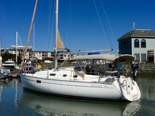 Slide: The Image of 2000 Beneteau Oceanis 321 sailboat docked in a marina under clear blue skies. - 43