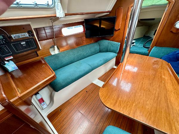 Slide: The Image of Interior of 2000 Beneteau Oceanis 321 sailboat with wood finish and teal seating. - 8