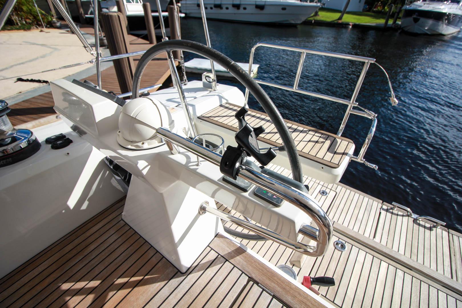 Slide: The Image of Steering wheel and cockpit of 2015 Beneteau Sense 55 yacht docked by the water. - 10