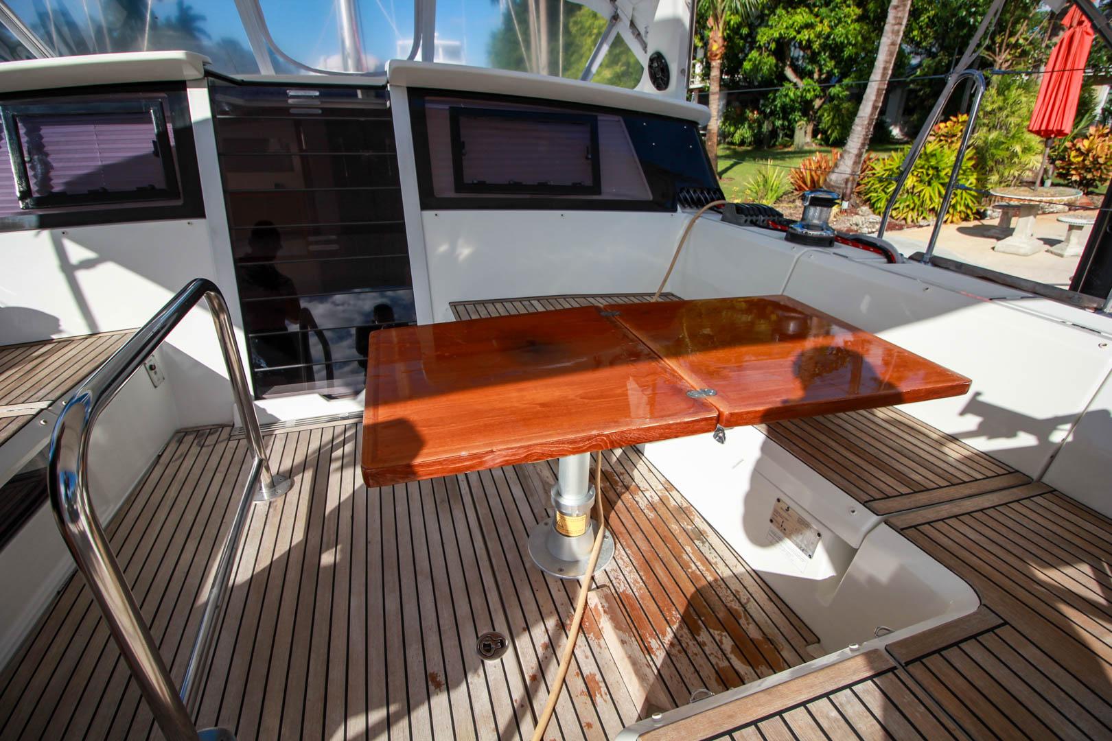 Slide: The Image of Cockpit of 2015 Beneteau Sense 55 yacht with wooden table and seating area. - 14