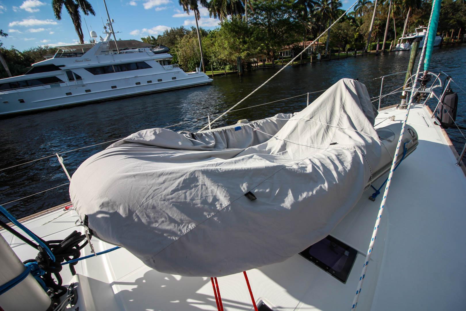 Slide: The Image of Beneteau Sense 55 sailboat deck with covered dinghy, docked near luxury yachts, 2015 model. - 22