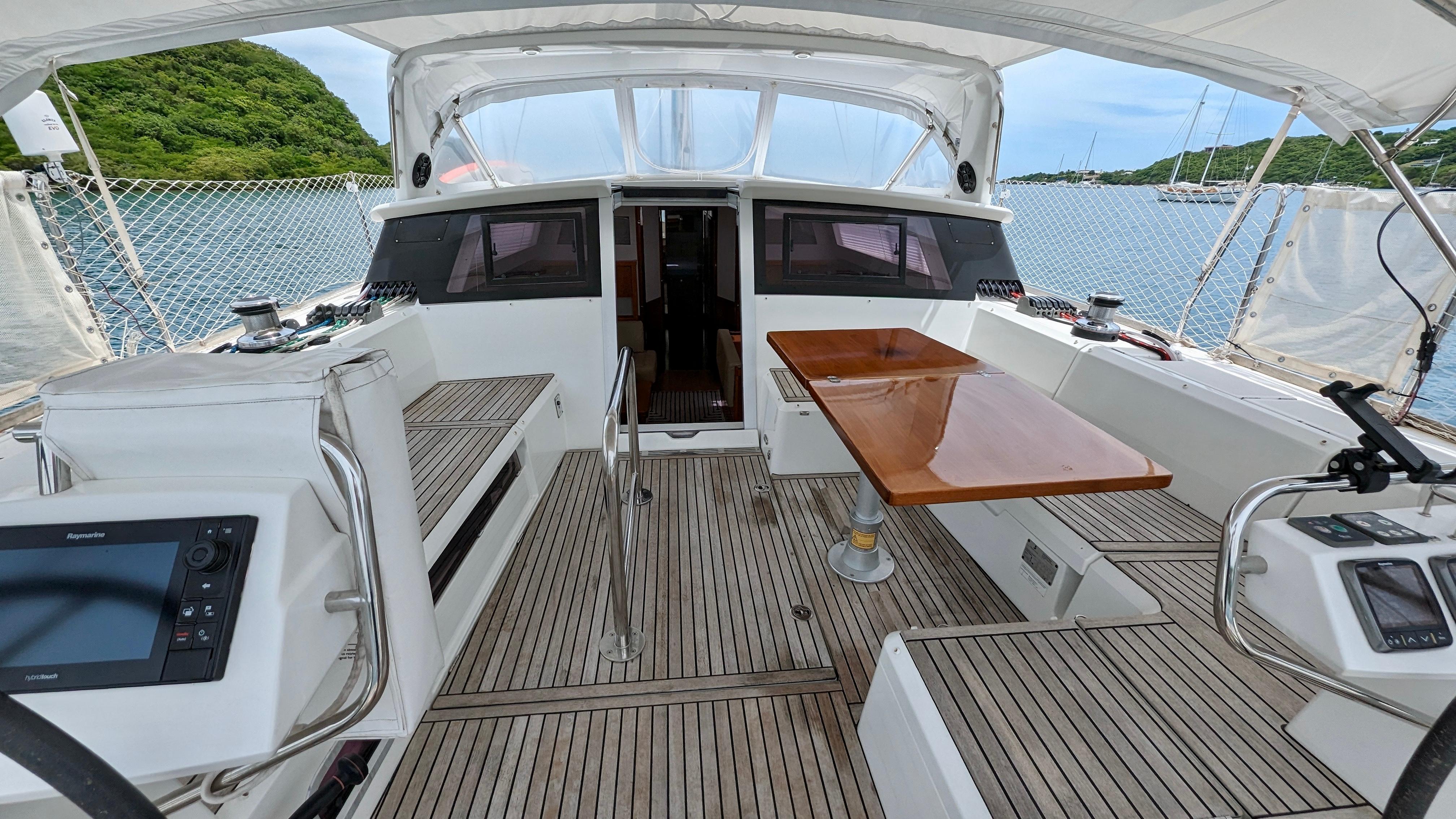 Slide: The Image of Cockpit of 2015 Beneteau Sense 55 sailboat with teak flooring and navigation equipment. - 24