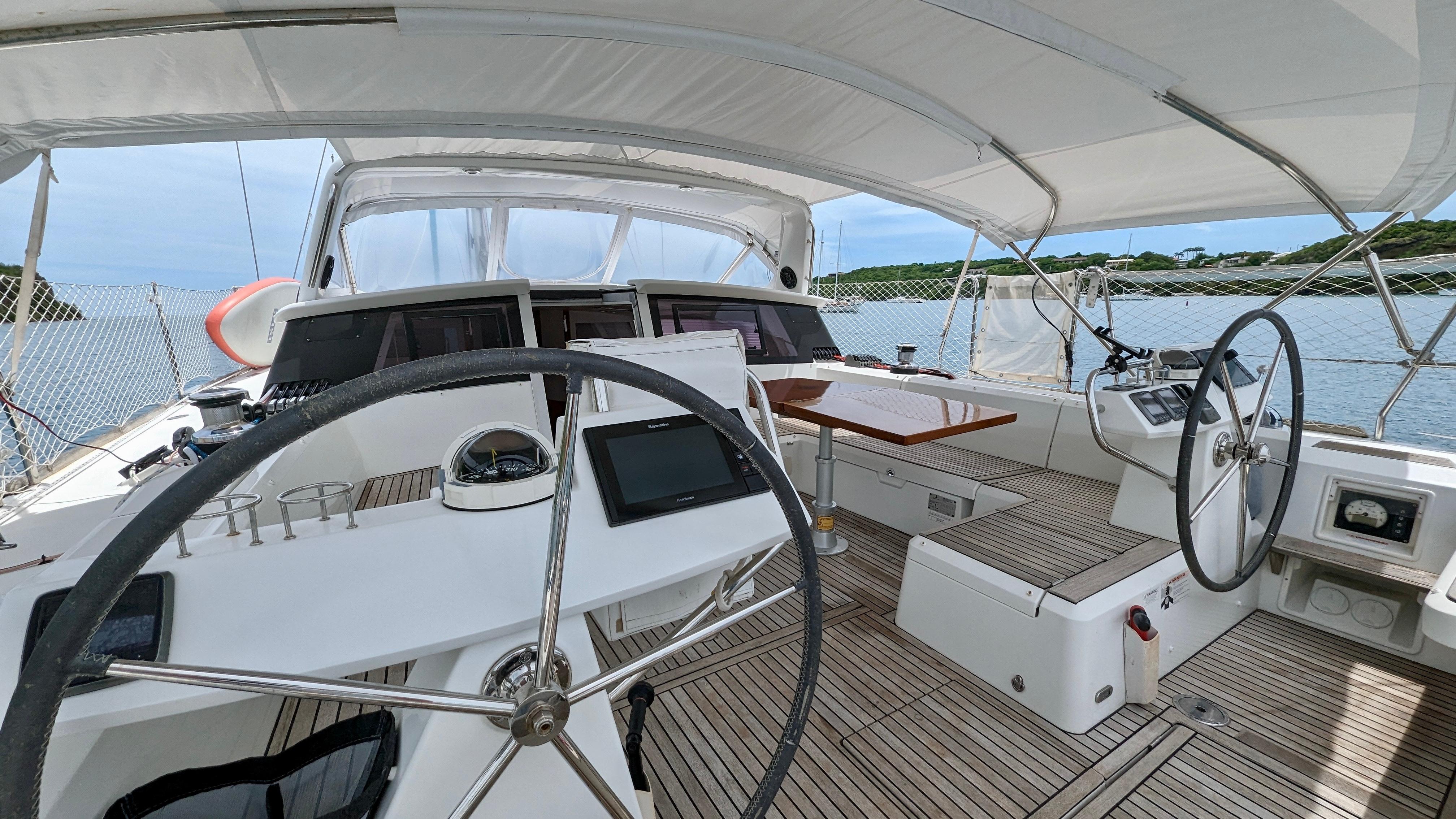 Slide: The Image of Cockpit of 2015 Beneteau Sense 55 sailboat with dual steering wheels and navigation equipment. - 26