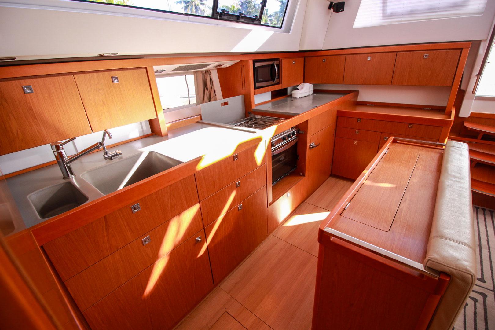 Slide: The Image of Modern kitchen interior of 2015 Beneteau Sense 55 yacht with wooden cabinetry and stainless steel appliances. - 33