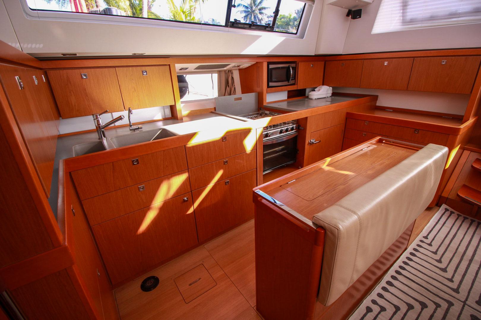 Slide: The Image of Modern kitchen interior of 2015 Beneteau Sense 55 yacht with wooden cabinetry and stainless steel appliances. - 36