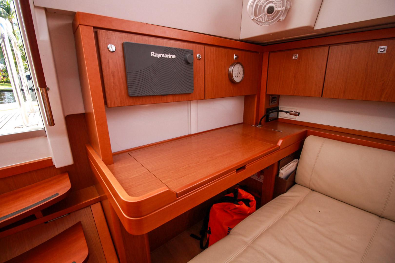 Slide: The Image of Interior of 2015 Beneteau Sense 55 yacht with navigation station and wooden cabinetry. - 37