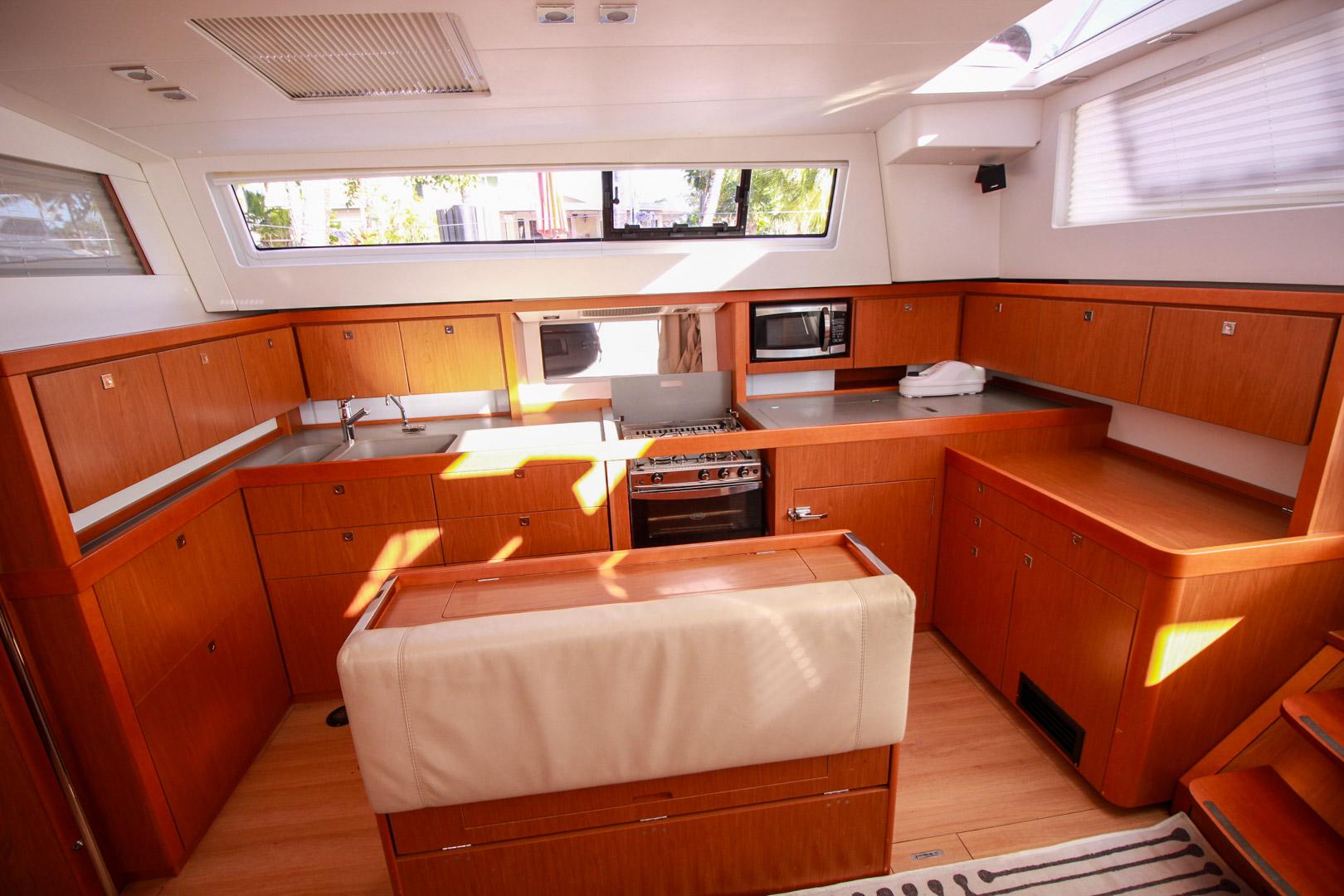 Slide: The Image of Modern kitchen in 2015 Beneteau Sense 55 yacht with wooden cabinetry and stainless steel appliances. - 38