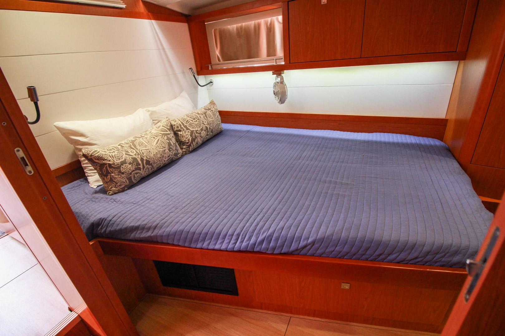 Slide: The Image of Cozy bedroom in 2015 Beneteau Sense 55 yacht with blue bedding and wooden cabinetry. - 40