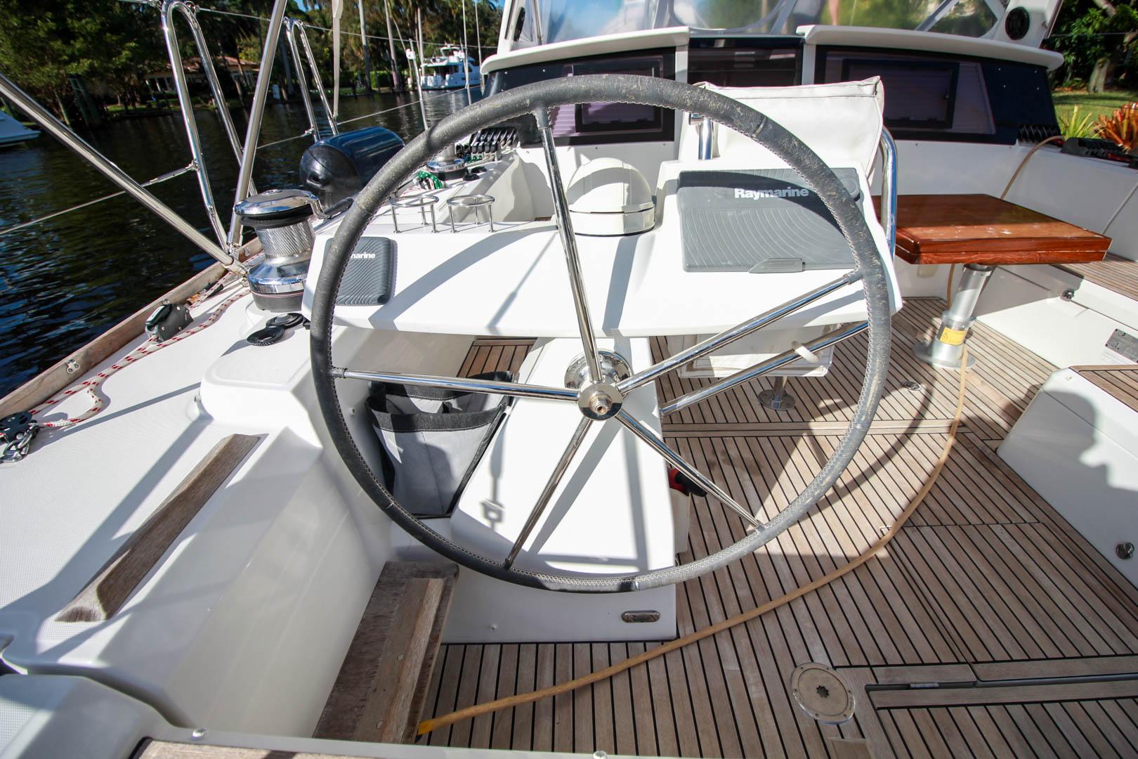 Slide: The Image of Cockpit of 2015 Beneteau Sense 55 sailboat with steering wheel and Raymarine equipment. - 8