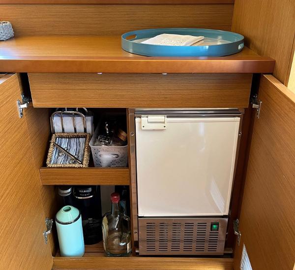 Slide: The Image of Interior of 2021 Beneteau Swift Trawler 41 with compact kitchen storage and mini fridge. - 15