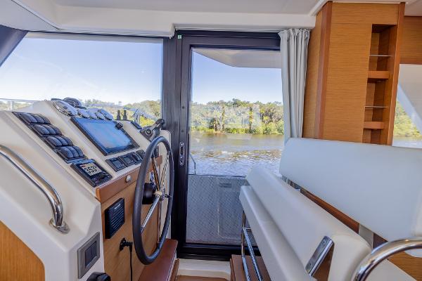 Slide: The Image of Helm of 2021 Beneteau Swift Trawler 41 with river view through window. - 17