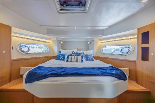 Slide: The Image of Luxurious cabin interior of 2021 Beneteau Swift Trawler 41 with cozy bedding and porthole windows. - 23