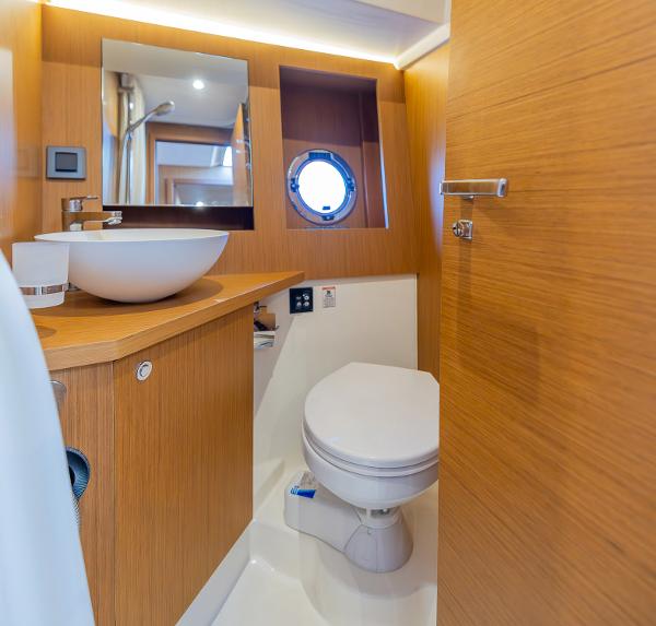Slide: The Image of Bathroom interior of 2021 Beneteau Swift Trawler 41 with modern fixtures and porthole. - 25