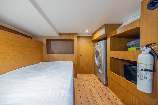Slide: The Image of 2021 Beneteau Swift Trawler 41 cabin with bed, washer, and storage shelves. - 30