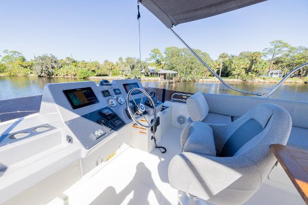 Slide: The Image of Flybridge helm of 2021 Beneteau Swift Trawler 41 with river view. - 40