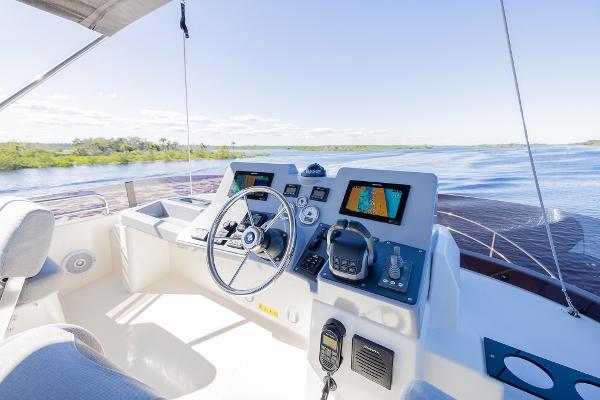 Slide: The Image of Helm of 2021 Beneteau Swift Trawler 41 with navigation equipment, overlooking serene waters. - 41