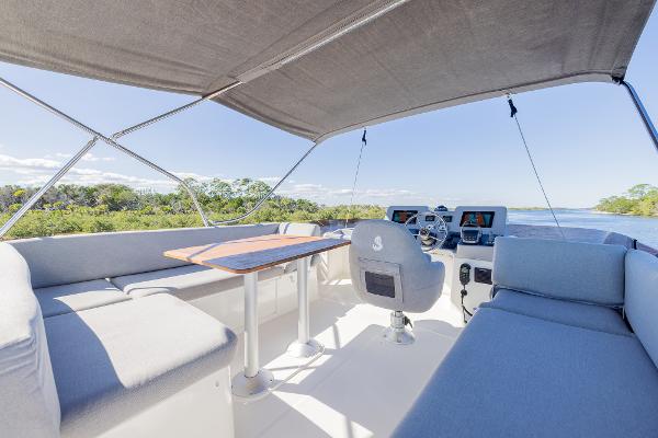 Slide: The Image of 2021 Beneteau Swift Trawler 41 flybridge with seating, table, and helm station under canopy. - 42