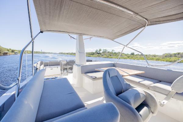 Slide: The Image of 2021 Beneteau Swift Trawler 41, spacious deck with seating, cruising on a sunny day. - 49