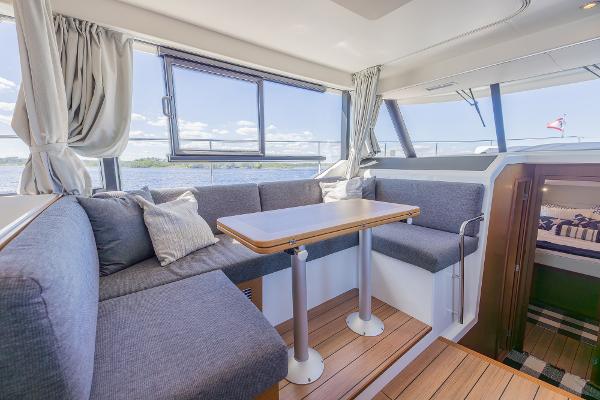 Slide: The Image of Interior of 2021 Beneteau Swift Trawler 41 with cozy seating and wooden table. - 5