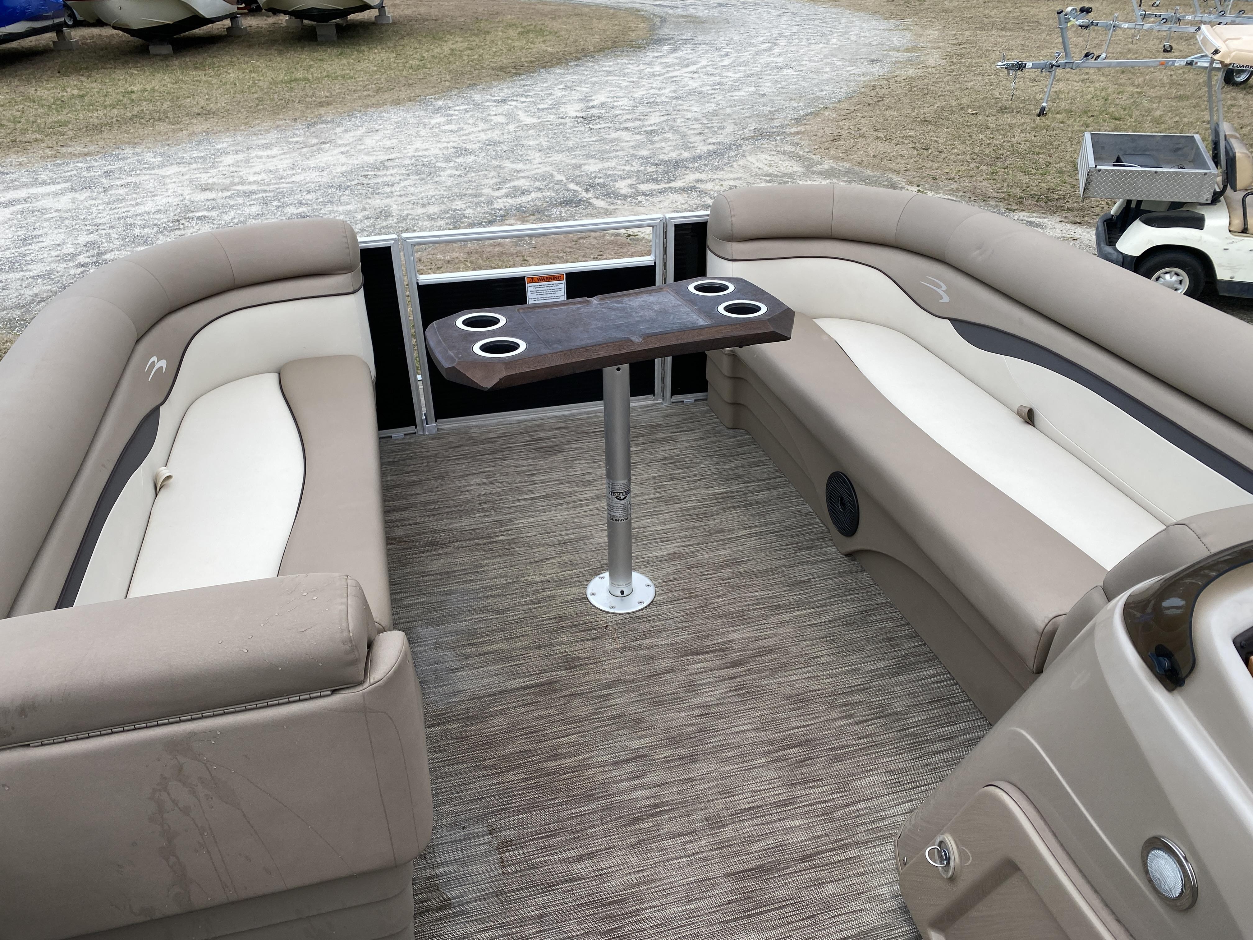 Slide: The Image of Interior of a 2021 Bennington 20 SSR pontoon boat with beige seating and a central table. - 10