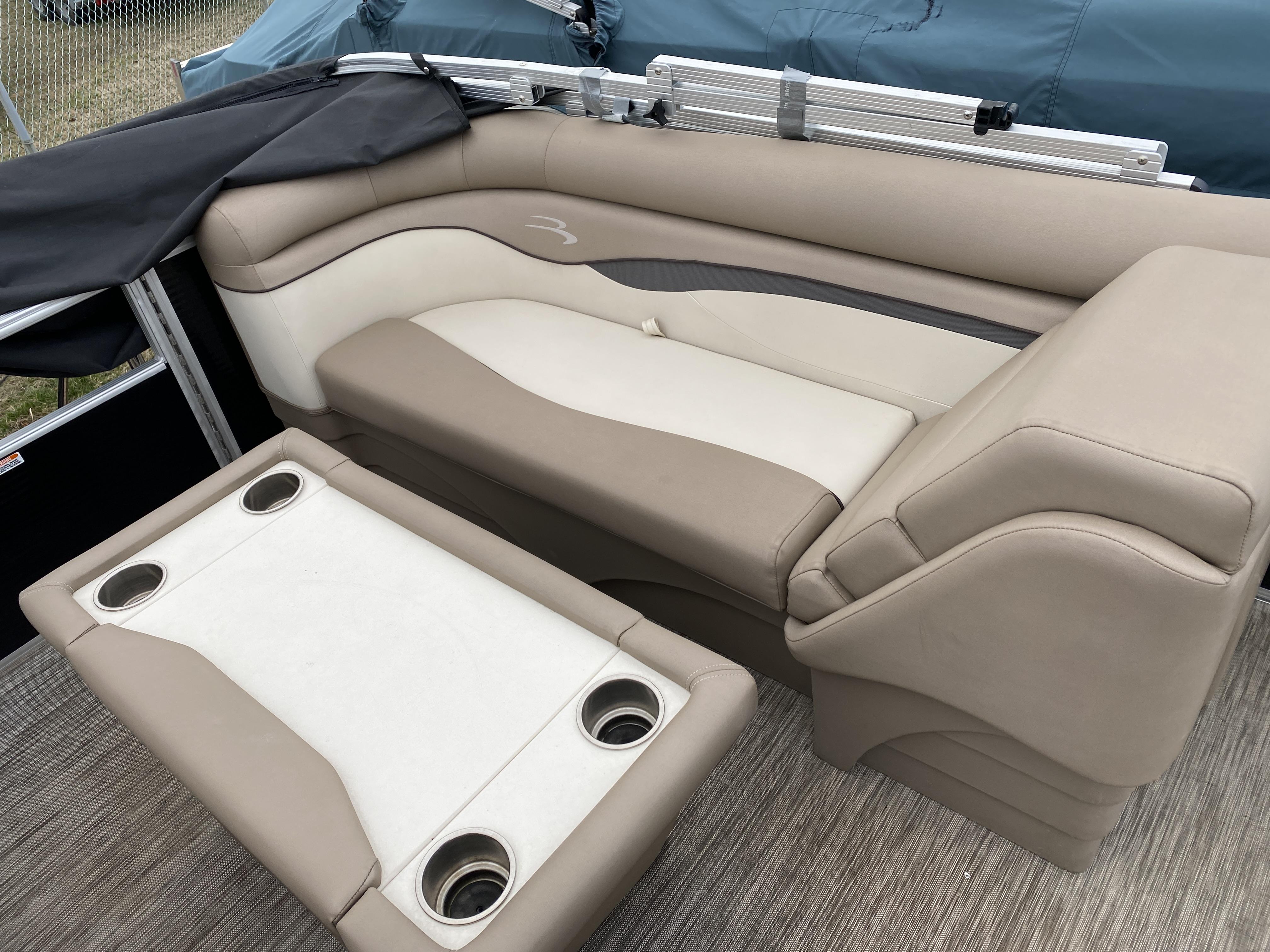 Slide: The Image of 2021 Bennington 20 SSR boat interior with beige and cream seating and cup holders. - 11