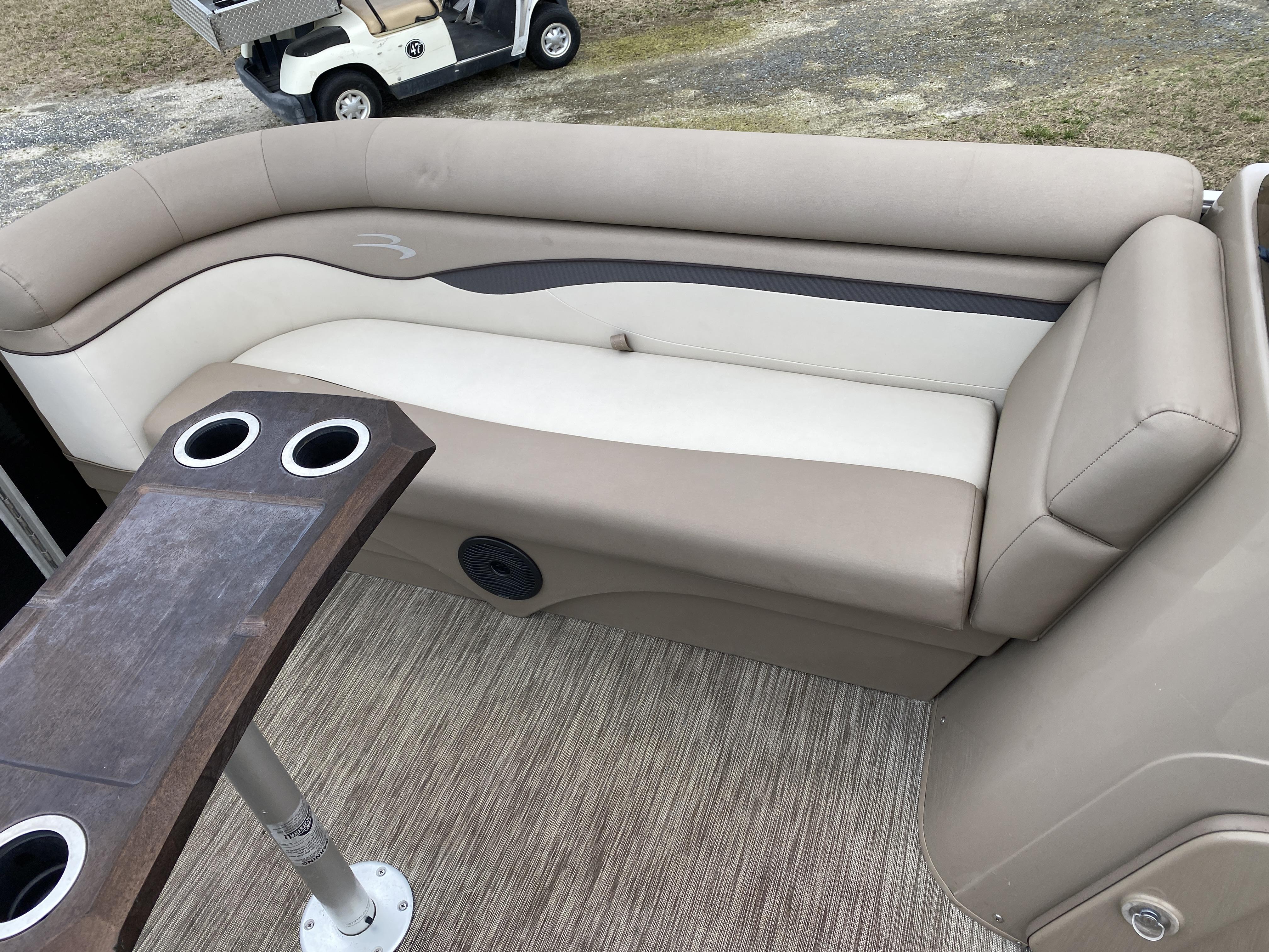 Slide: The Image of 2021 Bennington 20 SSR boat interior with beige seating and cup holders. - 4