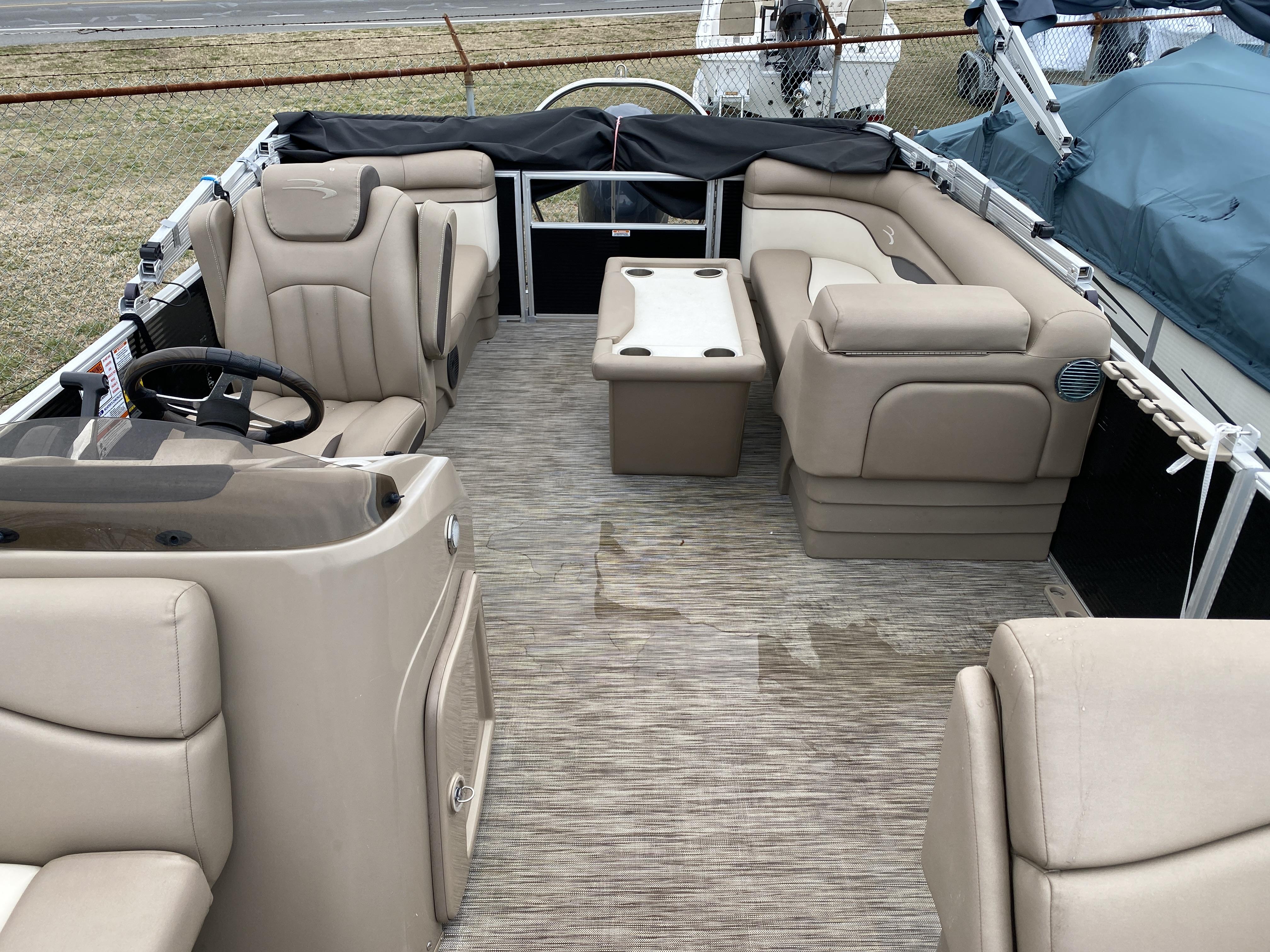 Slide: The Image of 2021 Bennington 20 SSR pontoon boat interior with beige seating and steering console. - 5