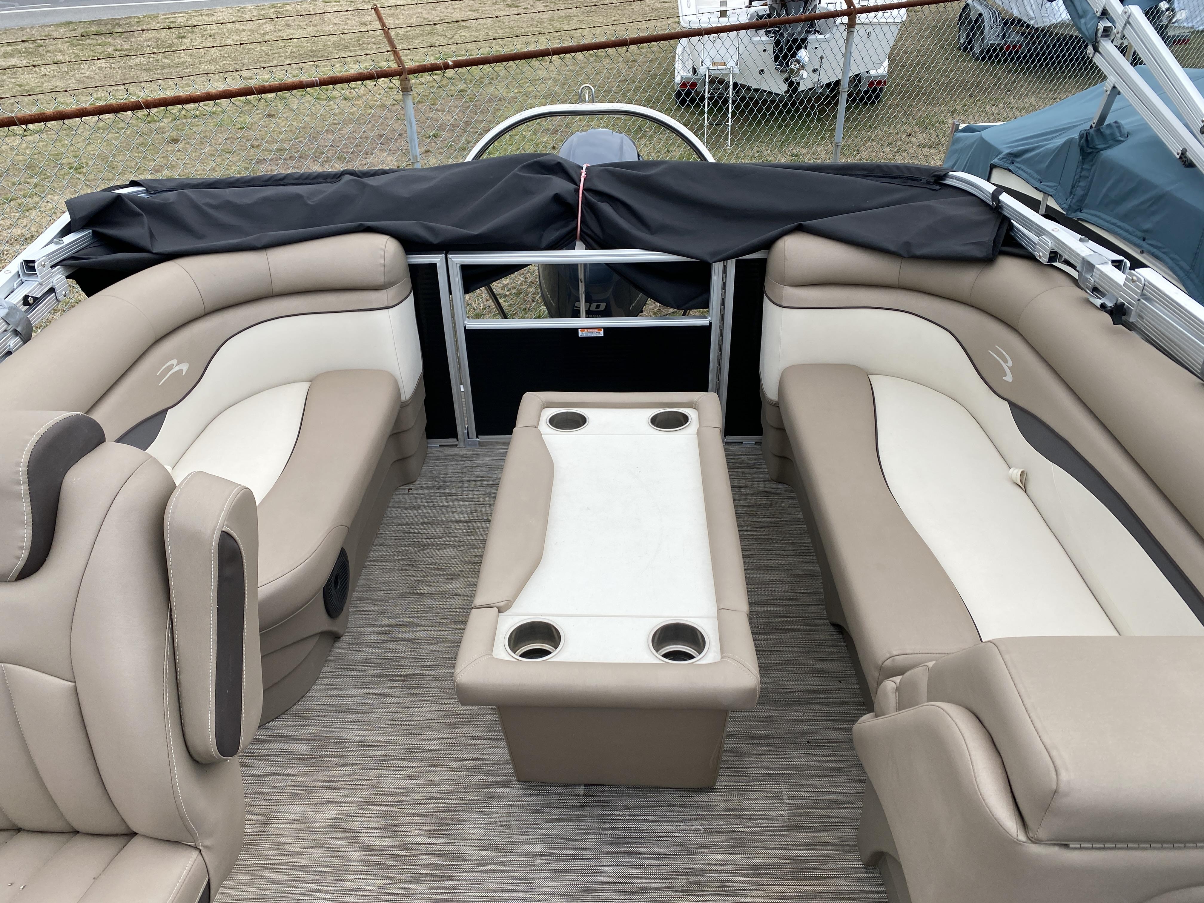 Slide: The Image of Interior of a 2021 Bennington 20 SSR pontoon boat with beige seating and a central table. - 6