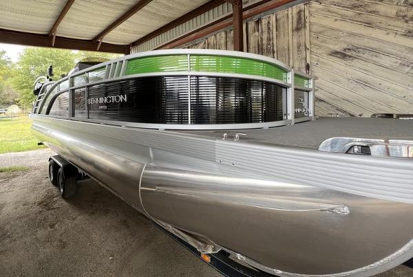 Slide: The Image of 2023 Bennington 23LTSB pontoon boat in a covered storage area. - 0