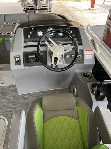 Slide: The Image of 2023 Bennington 23LTSB boat interior with steering wheel and green-accented seats. - 3