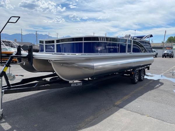 Slide: The Image of 2023 Bennington 25LTFB pontoon boat on a trailer in a parking lot. - 1