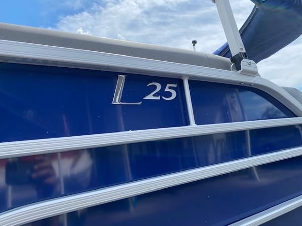 Slide: The Image of 2023 Bennington 25LTFB pontoon boat with blue exterior and L 25 marking. - 2