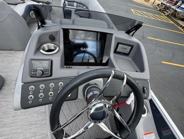 Slide: The Image of 2023 Bennington 25 QSBA boat dashboard with Garmin display and steering wheel. - 11