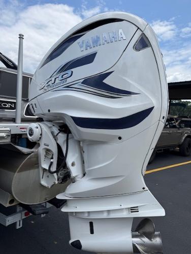 Slide: The Image of 2023 Bennington 25 QSBA with Yamaha outboard motor, parked on a sunny day. - 19