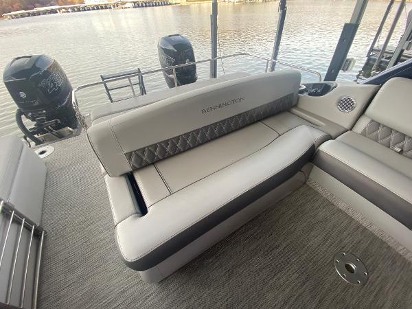 Slide: The Image of 2020 Bennington 30 QSBAX2 pontoon boat interior with plush seating and dual outboard motors. - 22